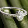 This stunning ring features an oval cut center stone with a gorgeous pave halo and side stones