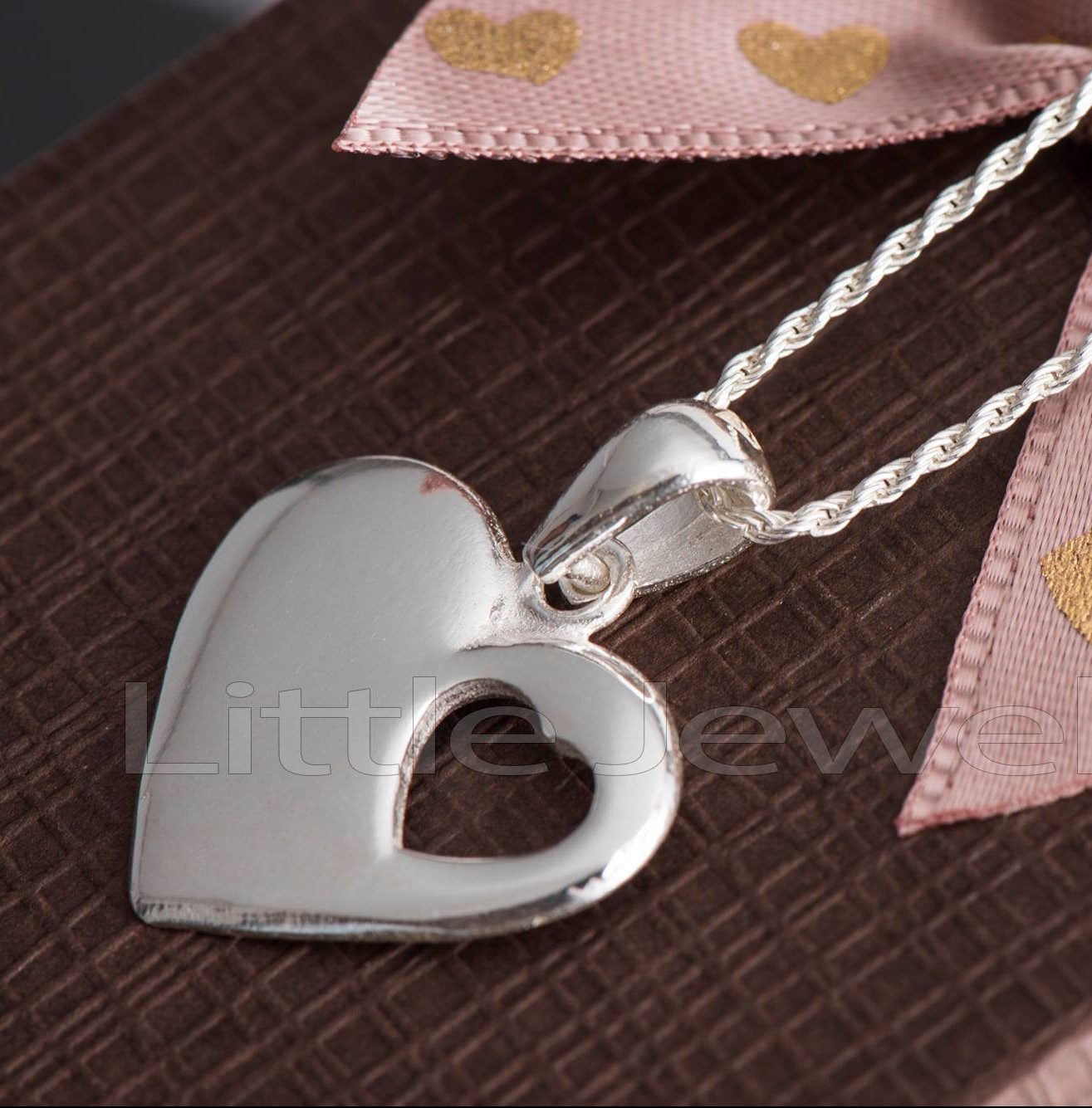 This sterling silver heart-shaped necklace has a smaller open heart at the bottom