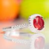 A captivating rich red halo design engagement ring