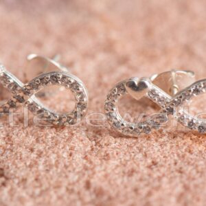 An enchanting pair of silver infinity earrings with a heart nestled among zirconia sparkles.