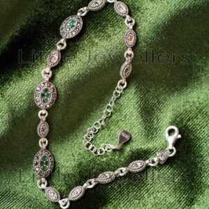 A vintage-style Marcasite bracelet made of pure sterling silver and set with green CZ stones.