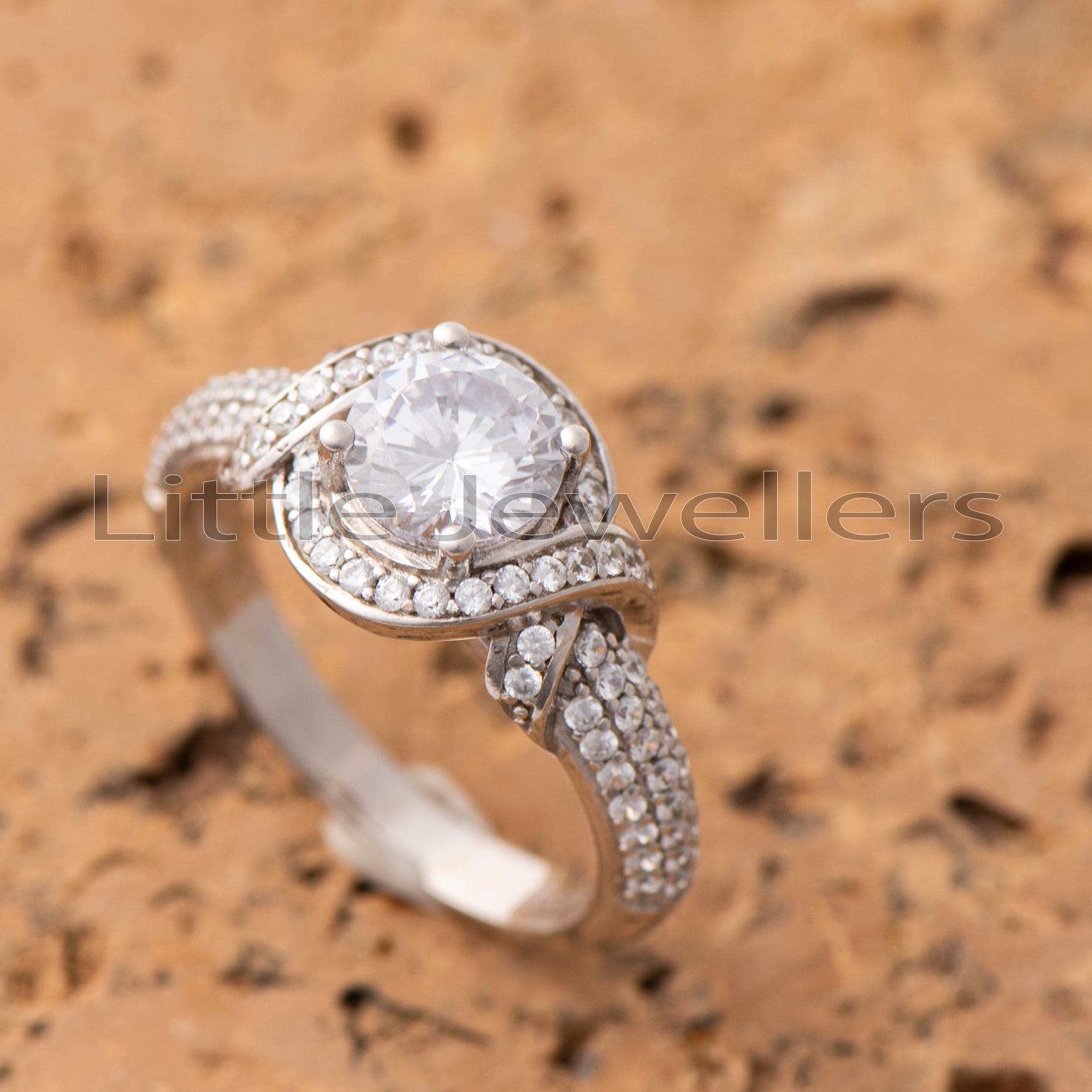 A brilliant round cut halo setting engagement ring set in 92.5% silver.