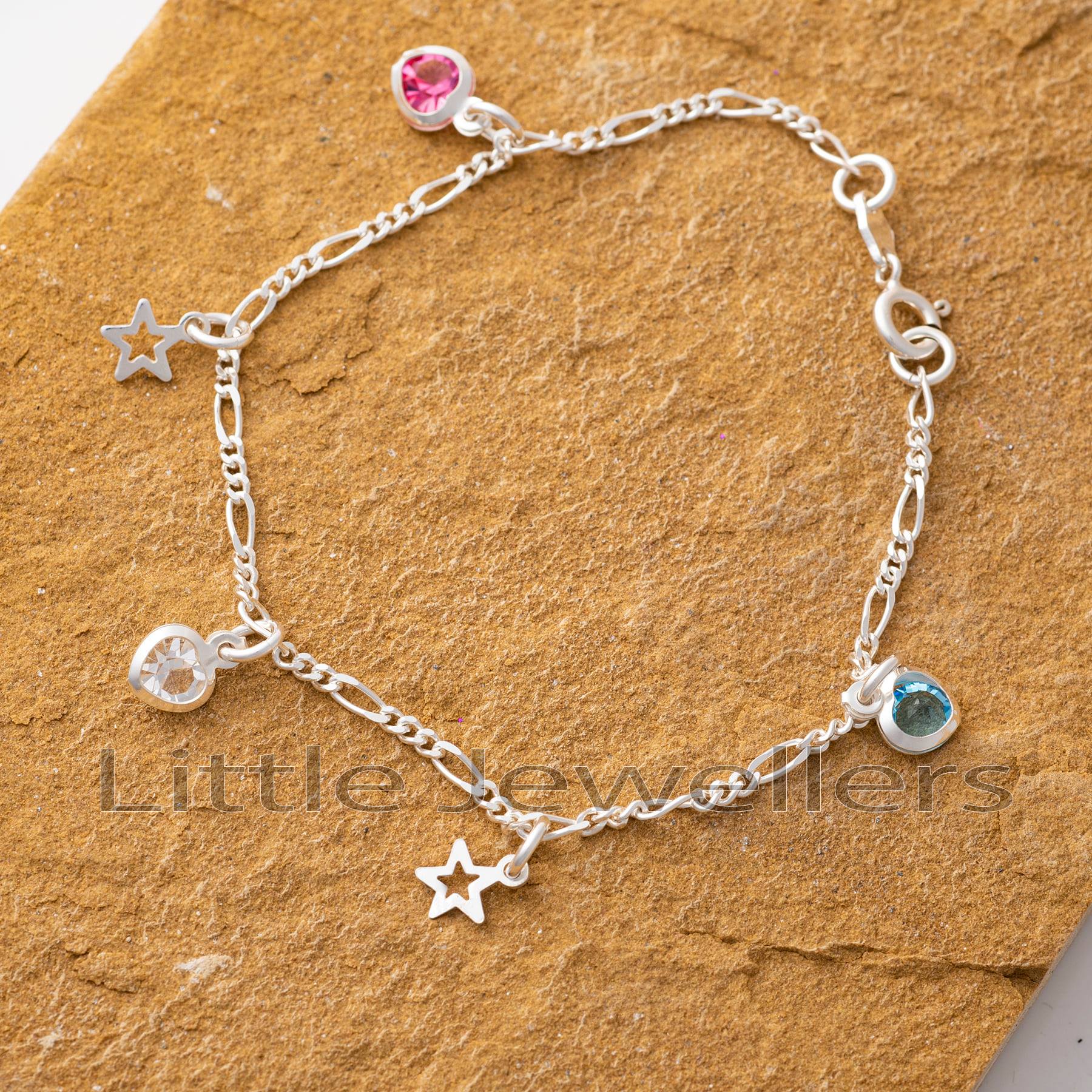 A delicate chain and tiny silver stars and hearts charms complement this sterling silver anklet.