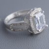 This clear emerald-cut ring features a large rock surrounded by micro pavé stones