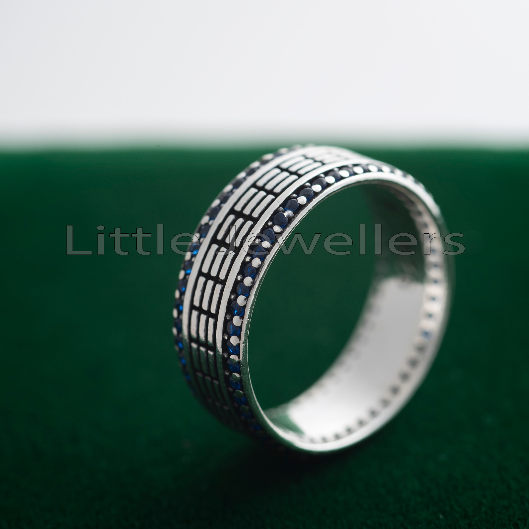 Show your love in style with this exquisite silver wedding ring. Featuring a unique pattern of small blue stones