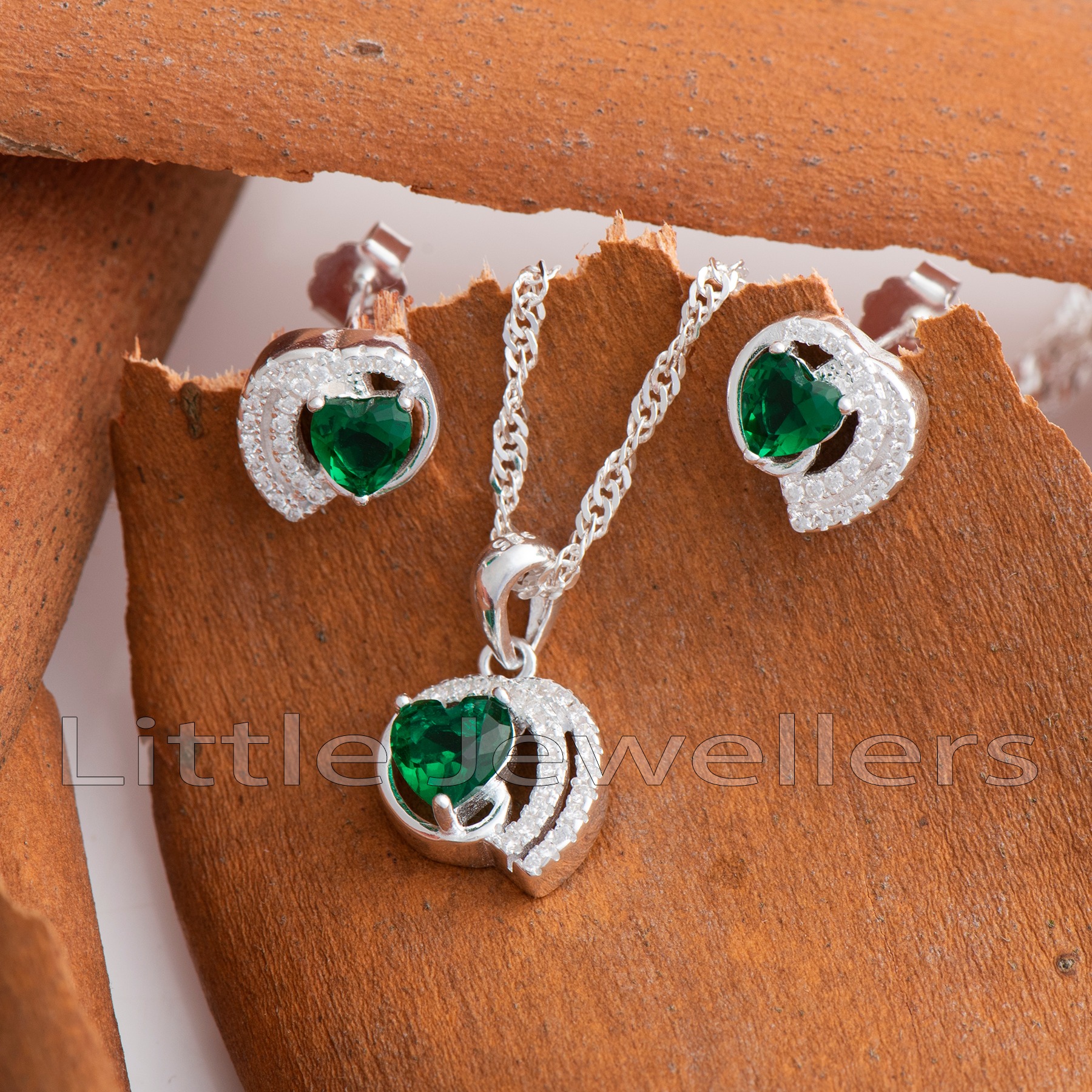 Make a beautiful fashion statement with this majestic necklace set that showcases a dazzling cz emerald green pendant and heart-shaped stone earrings. Make a lasting impression with this truly spectacular jewelry set