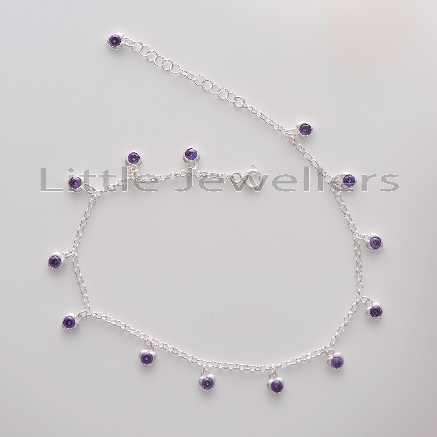 Add some sparkle and style to any outfit with this timeless and elegant silver anklet with purple heart-shaped charms. Durable and fashionable