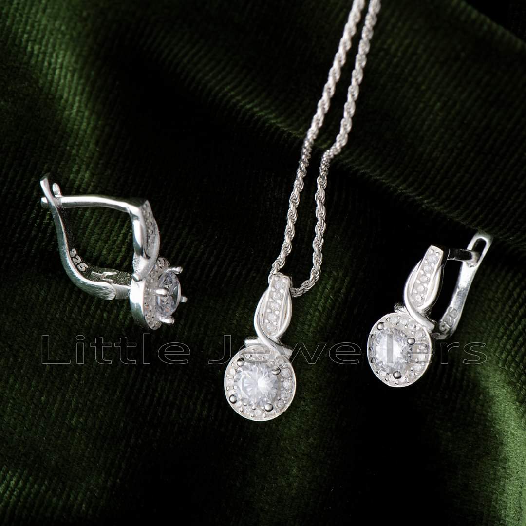 Make a statement with this dazzling silver necklace set. Featuring a delicate halo design pendant